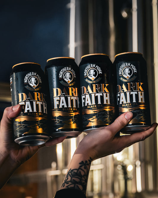 Four cans of 'Dark Faith' beer held up against a blurred background.