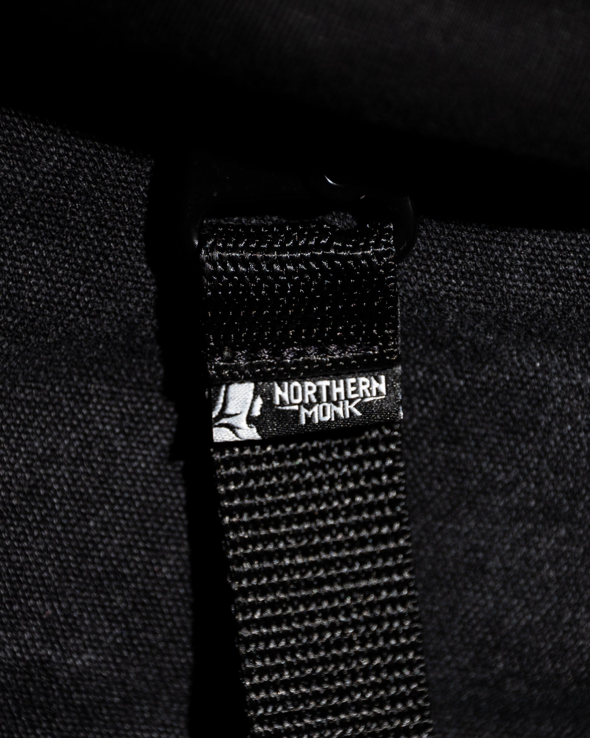 Black strap with a Northern Monk logo on a black background