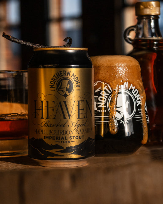 Can of Northern Monk Heaven Imperial Stout with a vanilla pod and maple syrup bottle in the background.