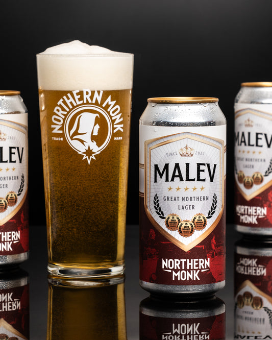 Northern Monk Malev lager cans and a glass of beer on a black background